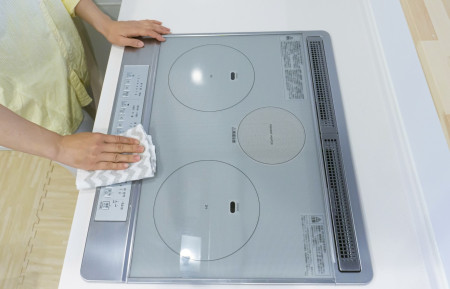 コンロ周りを掃除するママ