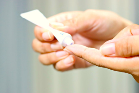 手に医療クリームを塗る女性