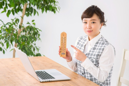 室内の温度・湿度を確認する女性