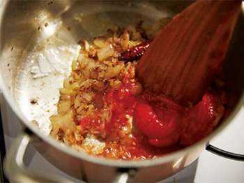 ホールトマトを加え、潰しながら水分がなくなるまで炒める。