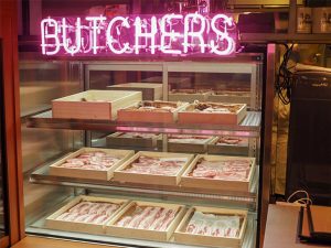 入口には店舗で使用する豚肉が豚バラ、肩ロース、豚トロなどに分けられて、まるでアート作品のように照らされています