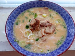 「テジクッパ」。豚肉ベースの白濁スープに、ネギとコチュジャン、豚肉が入っています。豚肉はとても柔らかく煮込まれていて、その濃厚な味がスープに溶け出しており、甘みもあります