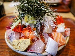 構造的に整理すると、皿の一番下には酢飯。その中央にどっさりとネギトロが載って、さらにその上に20種類以上の分厚くカットされたネタが、バラバラになって載っている