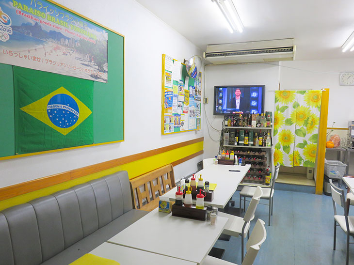 壁にかかっているテレビはブラジルの番組をオンエア中。その横にある求人情報などの張り紙や、店頭におかれたフライヤーもポルトガル語。異国情緒感たっぷり