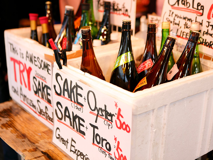 店の真ん中にある机の上には「SAKE・Oyster 500 SAKE・Toro 500」「TRY SAKE」など英語表記で書かれた紙と発泡スチロールが。中には一升瓶の日本酒がいろいろ