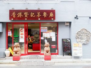赤い色と羊の置物が印象的な店の入口。大きな漢字の看板も2つあります