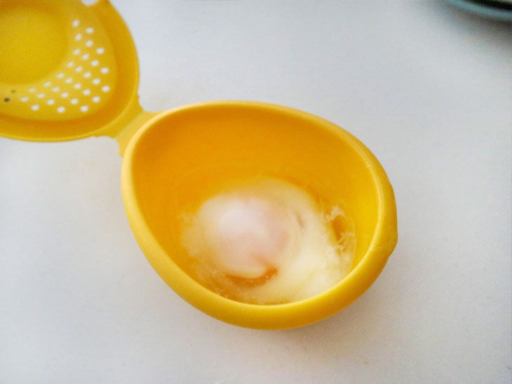 容器に生卵を落とし、卵黄に爪楊枝で4～6箇所穴を空けます。卵全体にかぶるくらいの水を入れて、電子レンジで約50秒（500W）