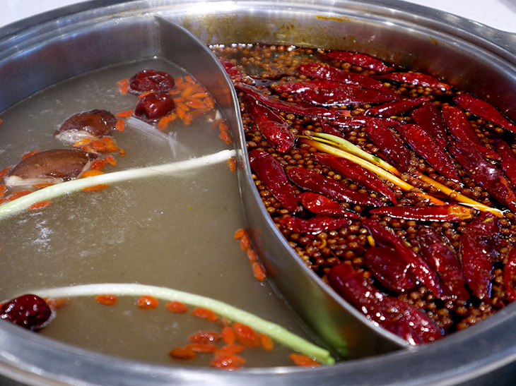 成都の火鍋。右の鍋には四川唐辛子と山椒がたっぷり入ったスープの「紅湯（ホンタン）」