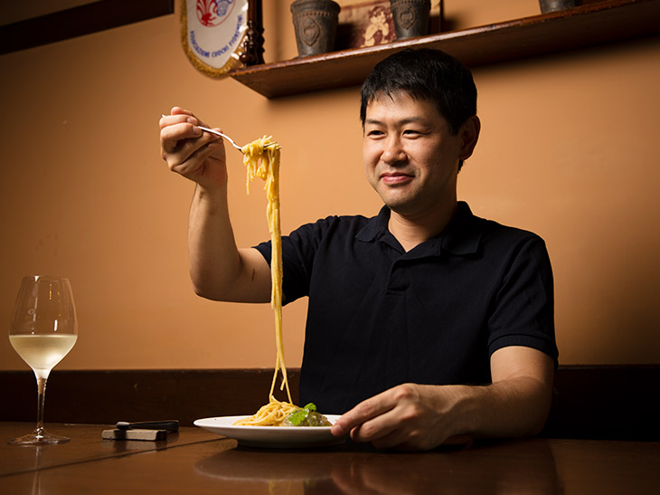 大好物の「カラスミの冷製フェデリーニ」を笑顔で味わう室田拓人シェフ。「素材を生かしたこの店の料理は、遅い時間でもすんなりお腹に入りますね」