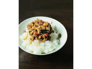 鍋に旨味をもたらす納豆はどうしても鍋底に沈んでしまう。そこで穴あきおたまで納豆や肉のカケラをすくい、ごはんにのせた〆に。さらりと粘りのない納豆ごはんは辛さの中に旨さが光る