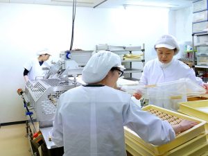作った餡を機械で“もなか”に詰め、品質などをチェック。5人ほどの職人が分業制で『空也』の和菓子を作っています