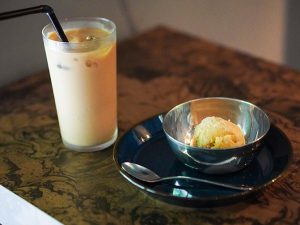 沖縄のラム酒を使用したラムレーズンアイス（450円）と、カフェラテ（500円）。カフェラテには、オーナーシェフの奥様が手掛ける『山田珈琲焙煎所』の自家焙煎コーヒー豆を使用