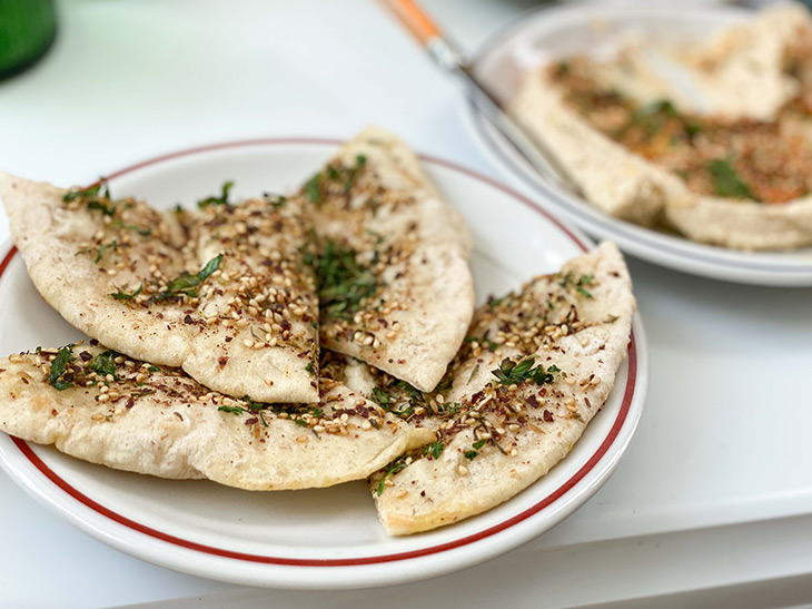 アラビア風うす焼きピザ「ザタール」1枚300円。上にのっている“ザタール”という中東の万能調味料は、ゴマやオレガノ、タイム、クミン、スマックなどを独自に調合して作る