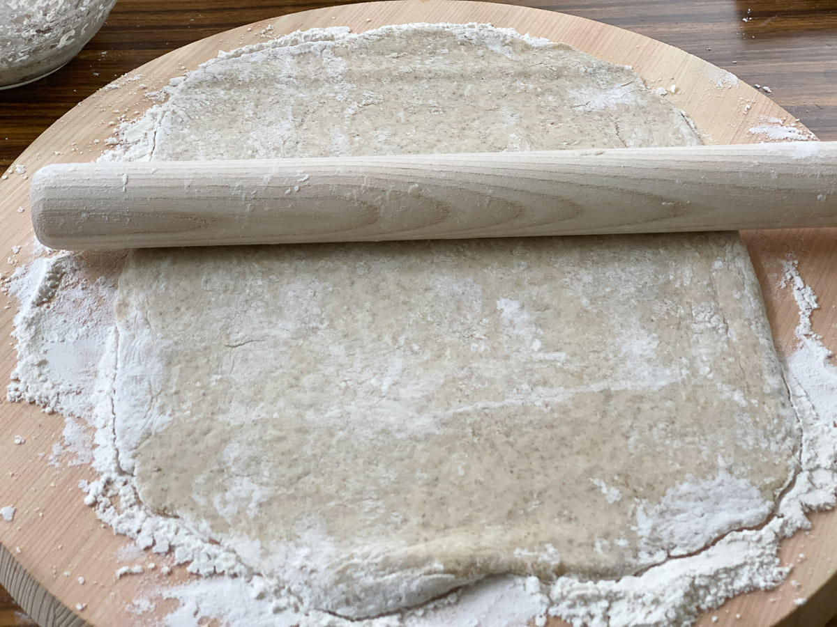 打ち粉をした台にパン生地を置き、2等分にします。1個ずつ、めん棒で長方形（縦12×横20cm）に広げる