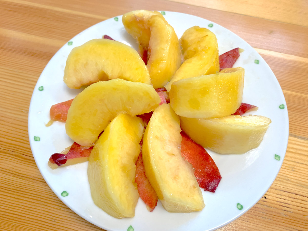 お皿に皮をのせて、その上に桃を並べるとすべらない。また、白いお皿に載せたときも色が映える