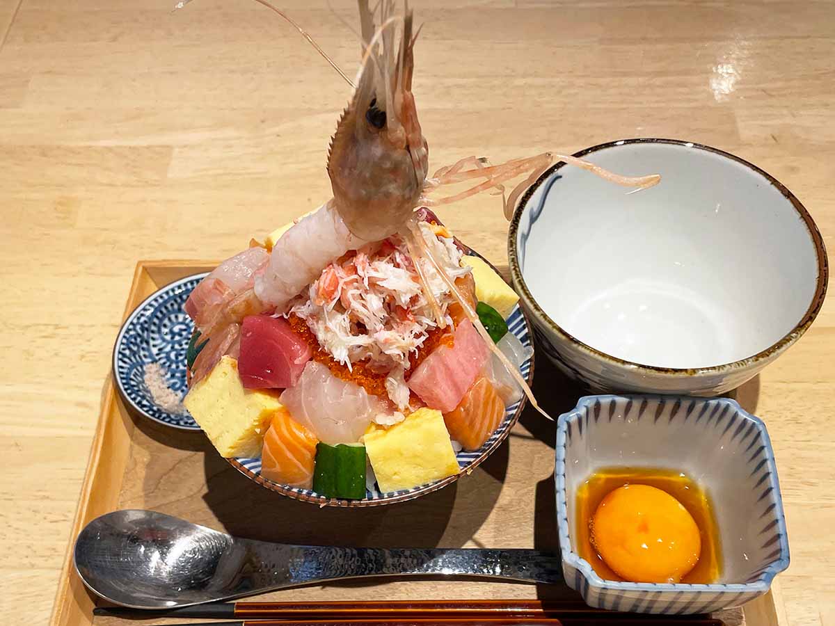 神田・西新宿に展開する『俺の魚を食ってみろ！！』がランチ限定で展開中の「究極の海鮮丼」990円（税込）。そびえ立つ海老の麓には、明らかに鮮度の良い高級ネタばかりが鎮座！