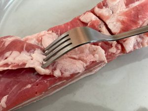 豚バラ肉の表裏にまんべんなくフォークで刺して穴を開けます