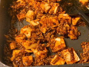 合いびき肉と「黒麻婆豆腐の素」を混ぜ合わせたら、豆腐を入れて2～3分煮込みます