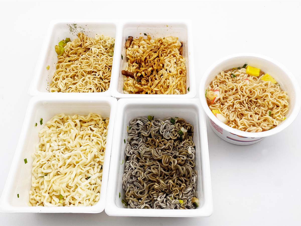 ペヤング(ペヨング含む)ブランドの商品群に湯入れしたところ。写真左奥から時計廻に「ペヤングソースやきそば」「味噌煮込みうどん」「ペヤングヌードル」「やき蕎麦風」「やきうどん」