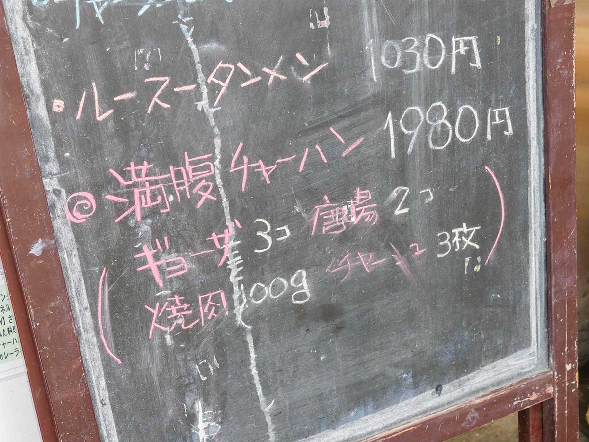 店頭にある黒板に書かれた「満腹チャーハン」の文字（※黒板には唐揚げ2コ、焼肉100gとありますが、現在は、唐揚げ3コ、焼肉150gに変更されている）