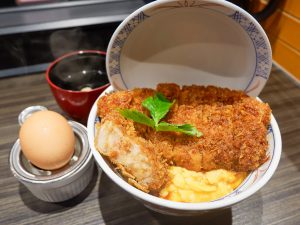 「＃とじないカツ丼」の登場です。トンカツの下にふわふわの卵が敷かれるスタイル。エッグセパレーターとともに生卵も登場