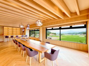 「SHINKA」を設計したのは空間デザイナー・大高啓司氏。テイスティングルームに鎮座する全長5mの山桜のテーブルが圧巻。窓からは豊かな田園風景が望める