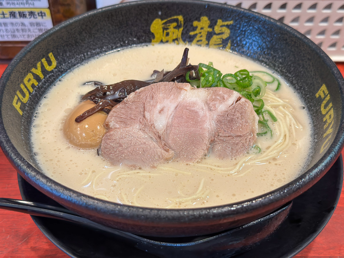 『とんこつラーメン博多風龍』の「元祖とんこつラーメン」750円。こちらは、ネギ増量と半熟玉子をトッピングしたので、900円。デフォルトのトッピングは、青ネギ、チャーシュー、きくらげ。