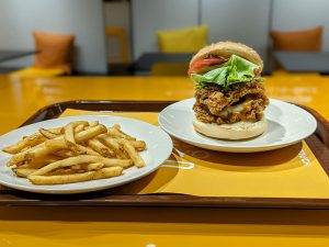 奥：鶏モモ肉2枚を挟んだ「サイフレックスバーガー」580円、手前：「ケイジャン風フライドポテト」270円