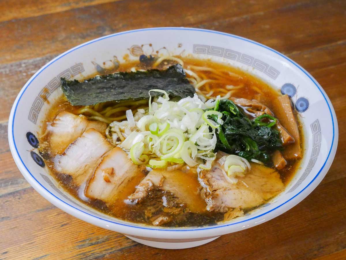 「ラーメン」1000円。券売機の一列目は「ラーメン」「チャーシューメン」「メンマラーメン」などの汁そば系、二列目に「つけめん」や「ざるラーメン」のボタンが並びます