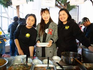 お惣菜を配る笑顔が素敵な3人組