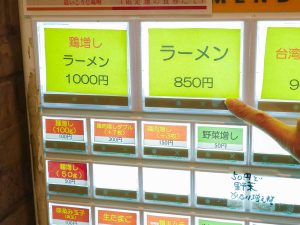 券売機。王道のラーメンにしつつ、麺増し（100g）＋100円と野菜増し＋50円で注文！