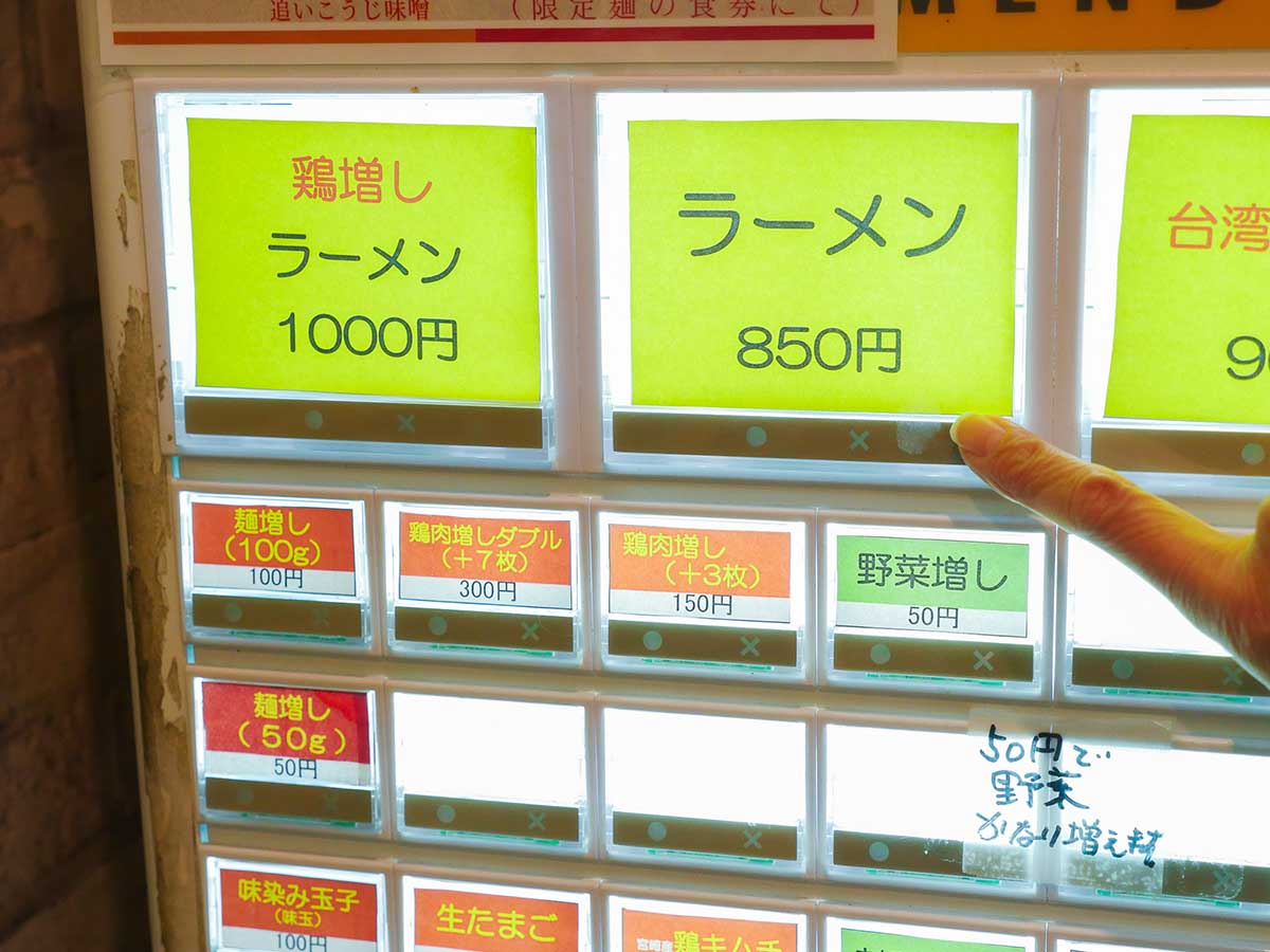 券売機。王道のラーメンにしつつ、麺増し（100g）＋100円と野菜増し＋50円で注文！