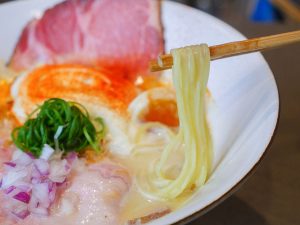 「天草大王」の力強さに野菜の優しい味わいを感じさせる口当たりの良いスープを絡め取る麺は、軽めのウェーブが施された卵麺