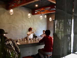 自然な風合いのモノトーンの空間にむき出しの天井の梁が調和する店内