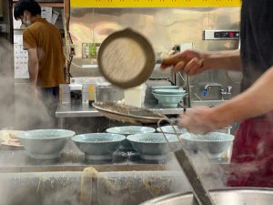 カウンター越しに中央の厨房で背脂をチャッチャする様子が見られる