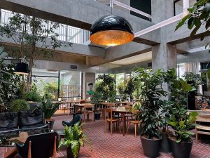 圧巻の吹き抜けの下にあるオールデイダイニング「the LOUNGE」。夜は宿泊者限定のアートラウンジになる