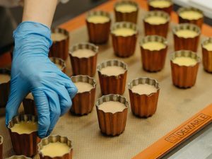 大倉山の店舗にある工房で一つずつ手作業で作られるカヌレ。型には蜜蝋と銅型を使用