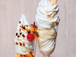 『円山牛乳販売店』の左「ポンポンプリンパフェ」1100円／右「別海町Wソフトクリームの白いパフェ」1401円（共にイートイン）