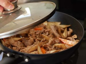 黒いフライパンの中で煮込むきんぴら