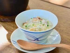白と青いラインの器に盛られたお粥