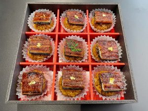 お刺身のようにそぎ切りした鰻2切れを酢飯にのせた「歓喜の一口鰻おむすび白」（9個入り、3800円、4個入りは2000円
