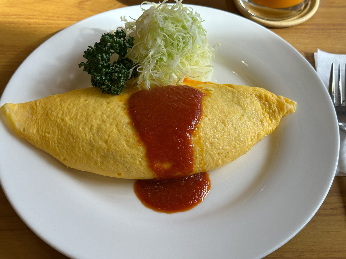 白い皿の上に盛られた赤いケチャップ付きのオムライス