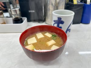 おかわり自由の「味噌汁」330円は、上には三つ葉、豆腐が浮かび、下にはなめこが沈んでいます。ちなみになめこのおかわりは＋100円