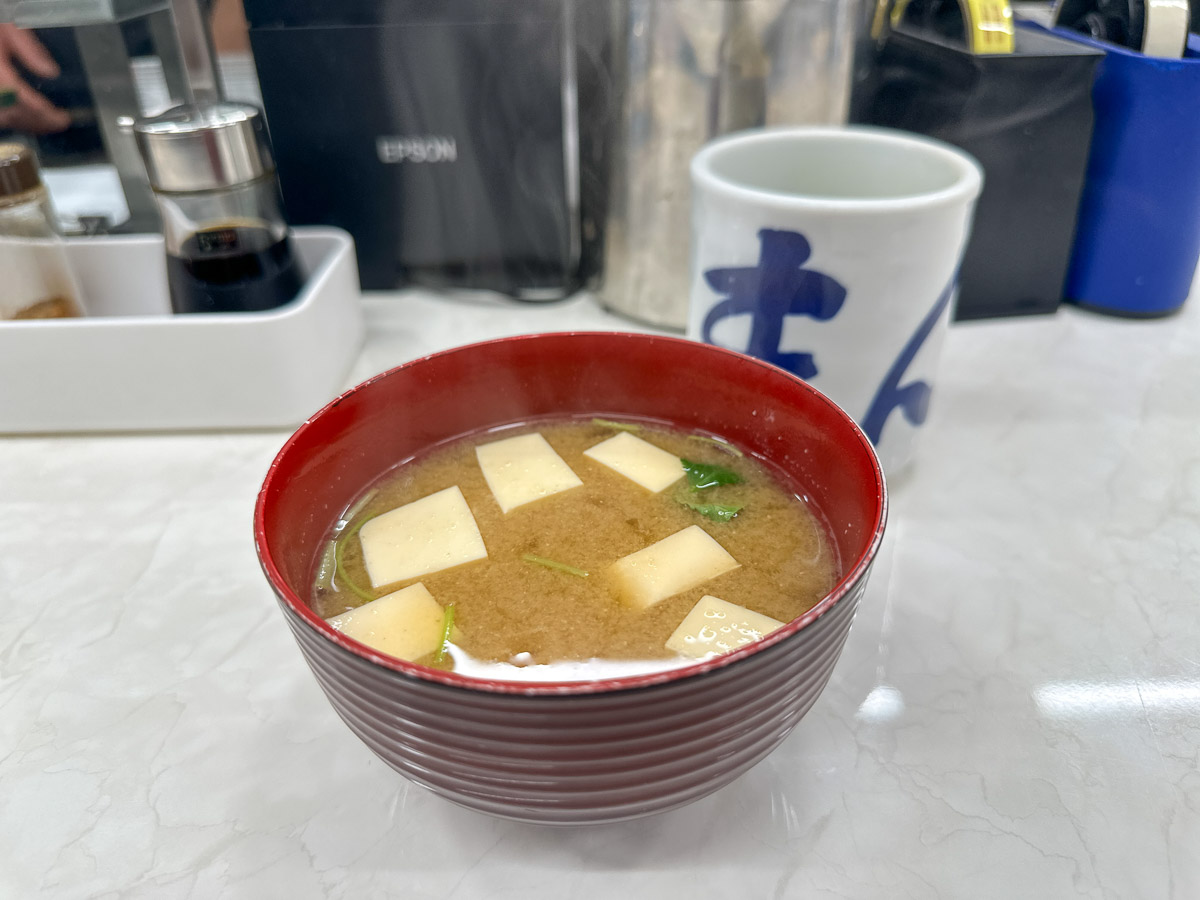 おかわり自由の「味噌汁」330円は、上には三つ葉、豆腐が浮かび、下にはなめこが沈んでいます。ちなみになめこのおかわりは+100円