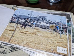 「本簾覆い（ほんずおおい）」の工程の一つ、高所で行われるワラ葺きの様子