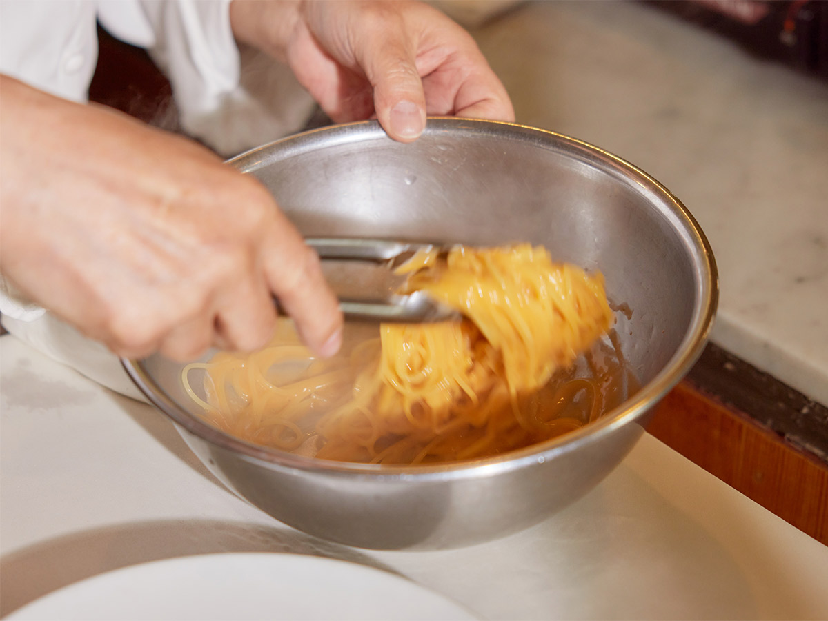 アルデンテにゆで上げたパスタに「うにのクリームソース」を手早く和えて仕上げる