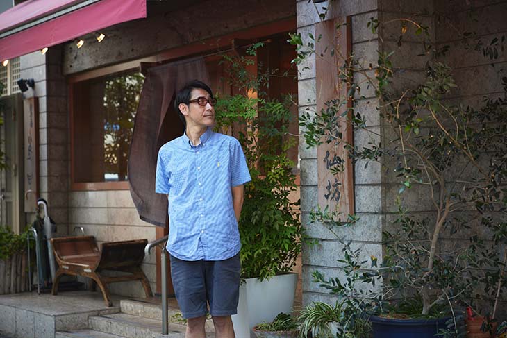小宮山雄飛さん 驀仙坊のお店の前に立つ