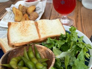 「上富良野産自家製ハムのホットサンド」1380円。付け合わせの七味枝豆も最高です！