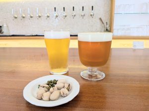 右から、定番の「ならまちエール」と、季節限定の「ならまちプレミアムクラフト」。どちらもレギュラーサイズで970円。1ドリンクオーダー制、ショート（約210ml）780円、レギュラー（約350ml）970円、トール（約480ml）1,280円。※季節限定メニューは価格やサイズが変わります