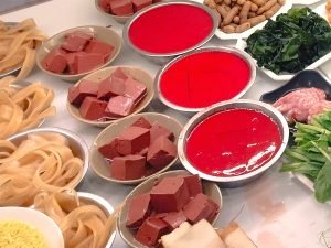 赤いボウルが鴨血（加熱前）。加熱したもの（赤いボウル横の四角い塊）も、串の棚に一緒に並んでいた